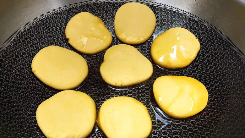 糯香南瓜饼,选用康巴赫不粘锅，热锅后倒入少于食用油，调至小火，把小圆团压成饼状放入锅中煎至金黄，