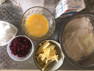 椰蓉蔓越莓月饼,准备好材料备用，蔓越莓切碎、黄油切小块，鸡蛋打散