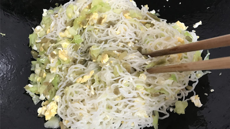 鸡蛋榨菜炒米粉,最后把泡好的米粉放入锅中，用筷子把米粉和配菜一起快速翻拌均匀。