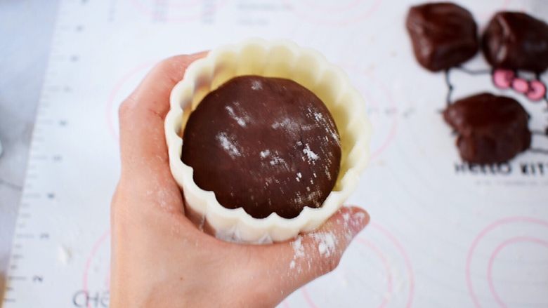 巧克力流心月饼,表面再撒上适量的手粉，放入月饼模具中，按压平整