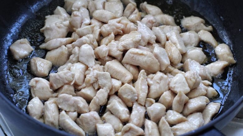 豆豉炒鸡丁,锅中倒适量食用油烧热，放入腌制好的鸡丁滑炒至变色断生状态，盛出