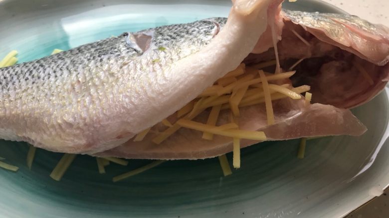 芽芽私房菜@葱油鲈鱼,放上鲈鱼，并且在鲈鱼肚子里塞进去适量生姜