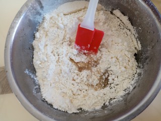 自制豆沙蛋黄月饼,用刮刀搅拌均匀揉成光滑的面团