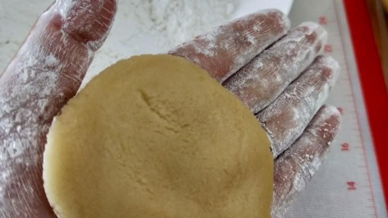芝麻馅月饼,取一饼皮用手掌压成饼状。