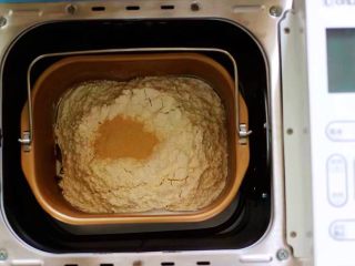 杏仁牛角面包,所有的食材称重备用，除黄油外的食材，全部加入面包桶中，先液体在粉类的顺序放入，最后在上面放入酵母粉，用面粉将酵母粉盖起来。