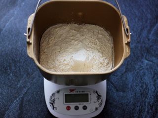 超级萌哒的毛毛虫豆沙面包，哄娃神器,首先把各种食材称重后，把牛奶倒入面包桶，再加入鸡蛋，糖和盐对角放，加入高筋面粉，奶粉，再面粉的顶端挖个小洞，再用旁边的面粉将酵母粉盖起来。