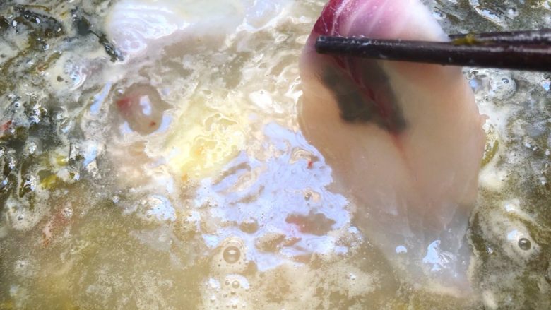 海底捞上汤酸菜鱼,把鱼片一片一片放到汤里，直至全部放完