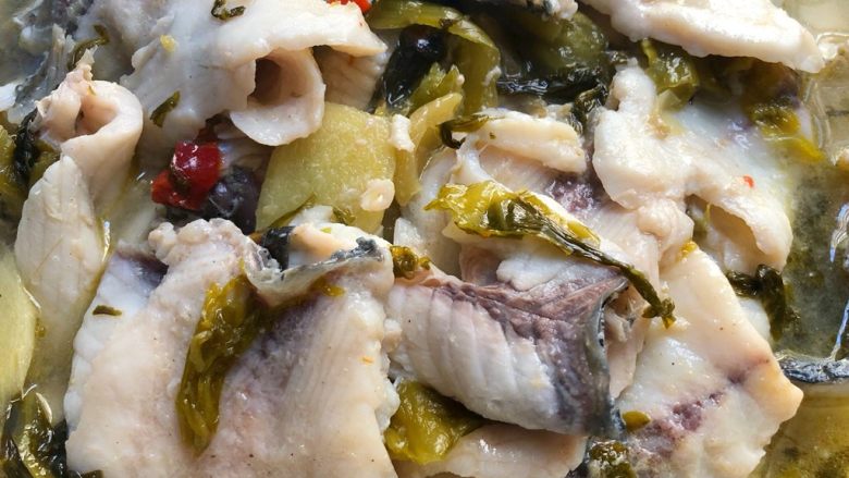 海底捞上汤酸菜鱼,把煮熟的鱼片倒入码有鱼头的碗里