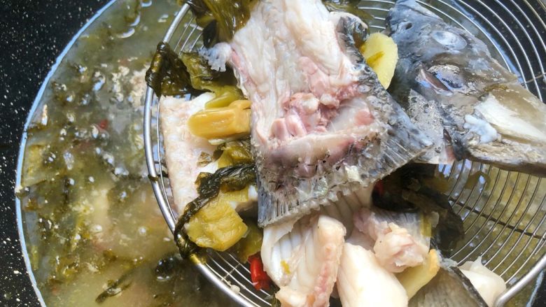 海底捞上汤酸菜鱼,鱼头鱼骨煮熟，捞出来码入碗底