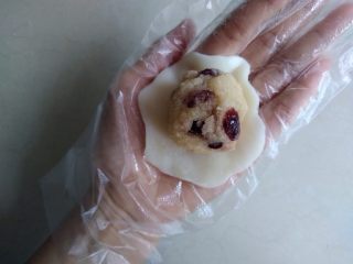 椰蓉蔓越莓冰皮月饼,饼皮分成每个25克，在手掌上压扁放入馅料。