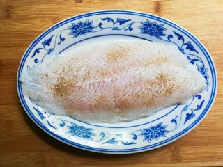 生抽巴沙鱼,盘中放入巴沙鱼撒上少许黑胡椒粉