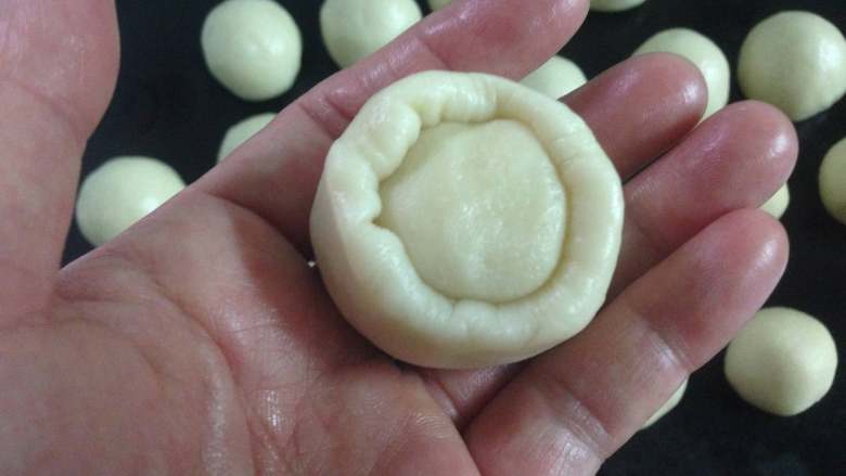 芝士大虾月饼,取一个油皮按扁，放入一个油酥， 把油皮慢慢地往上推包住油酥。