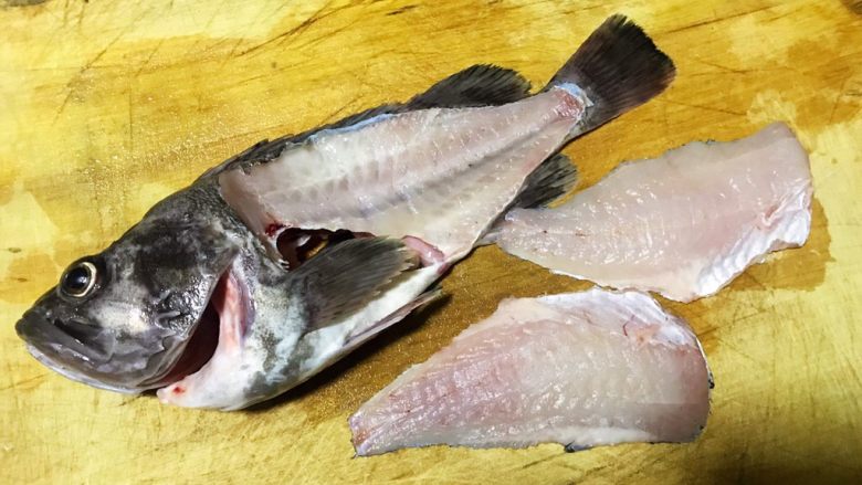 黑鱼刺身,摁住鱼头从鱼头靠近腹部开始片鱼肉将两侧鱼肉沿着鱼骨剔下来再把鱼腹部的大刺片下来
