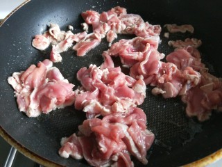 新文美食  葱爆猪肉片,先用不沾锅烧热倒入适量油，倒入肉片。