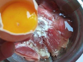 新文美食  葱爆猪肉片,打开一个鸡蛋倒入蛋青。