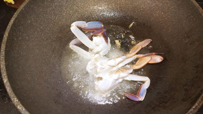 咖喱蟹,锅中倒入多点油烧热后，将蟹粘着生粉的一面放入炸一下