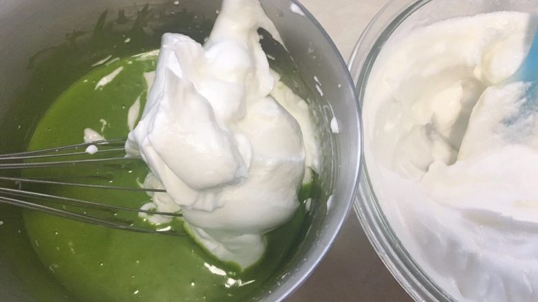 菠菜汁蛋糕,取一部分打发好的蛋白霜，加入到菠菜面糊中，先用蛋抽翻拌均匀