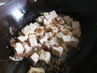 新文美食  家常豆腐,放入肉馅炒散，加入豆腐炒均匀。
