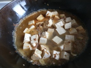 新文美食  家常豆腐,加入适量酱油，在加入适量开水。