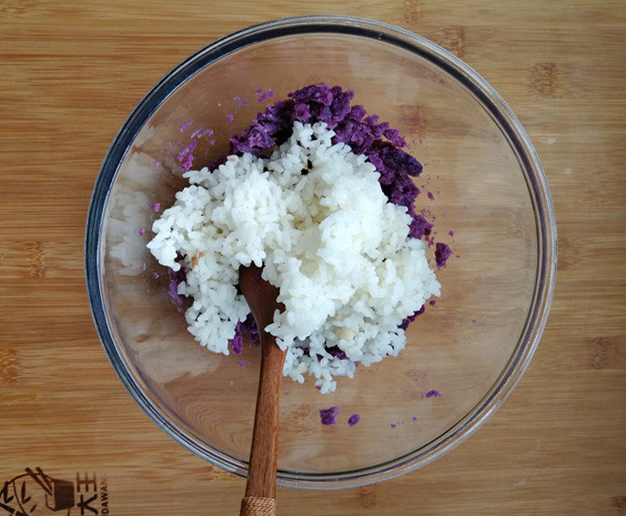 紫薯米饭香肠卷,紫薯碾成泥状。直接用勺子背压，或者戴上一次性手套，用手抓匀。加入米饭。