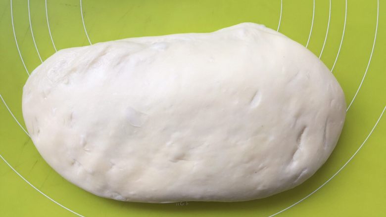 蔓越梅手撕面包,将面团按压排出大气泡，之后将面团揉至表面光滑，盖保鲜膜松弛；