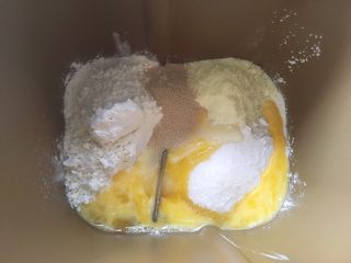 蔓越梅手撕面包,面包桶内加入高筋面粉、低筋面粉、细砂糖、全蛋液、奶粉、15克炼乳跟酵母；

