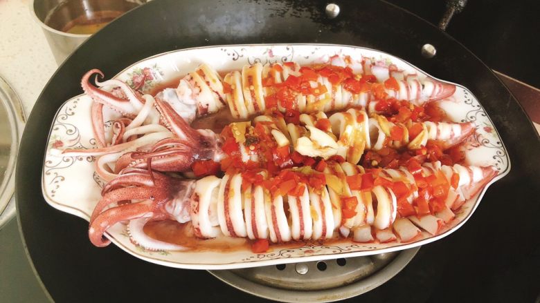 剁椒鱿鱼-下饭菜,锅里放水和蒸架，放上鱿鱼大火蒸15分钟。