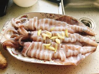 剁椒鱿鱼-下饭菜,鱿鱼淹好后，铺上3片姜和2颗蒜。