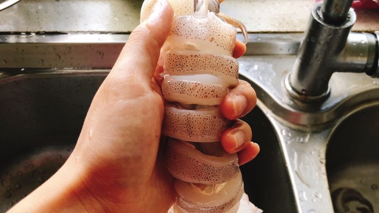 剁椒鱿鱼-下饭菜,水龙头的水直接冲到鱿鱼肚子里清洗，手指伸到各节圆圈缝里清理内脏及墨鱼骨。
