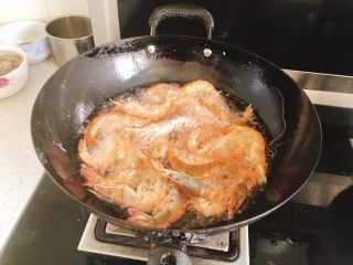椒盐甜酒虾,油温热时，将虾全部倒入油炸。