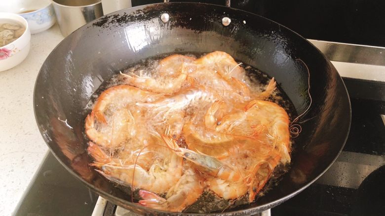 椒盐甜酒虾,油温热时，将虾全部倒入油炸。