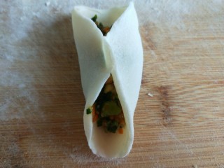 新文美食  鸡蛋韭菜饺子,放入馅料，中间捏紧，在包成饺子。