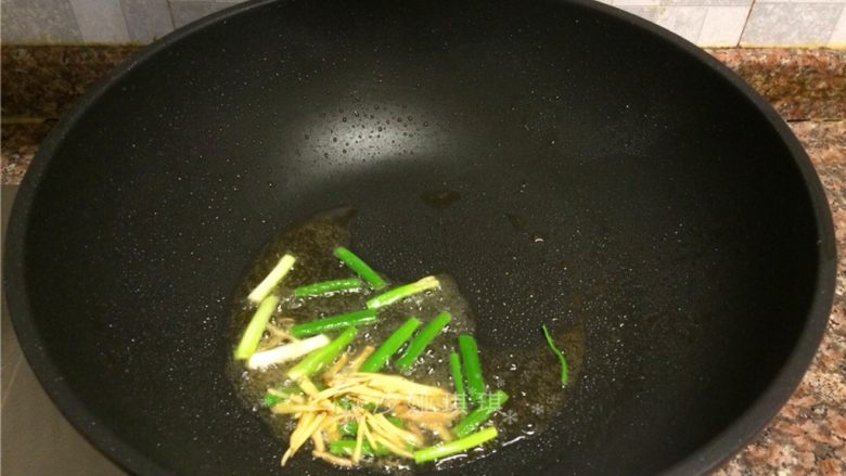 酱香烧鲈鱼,放入葱和生姜丝翻炒出香味。