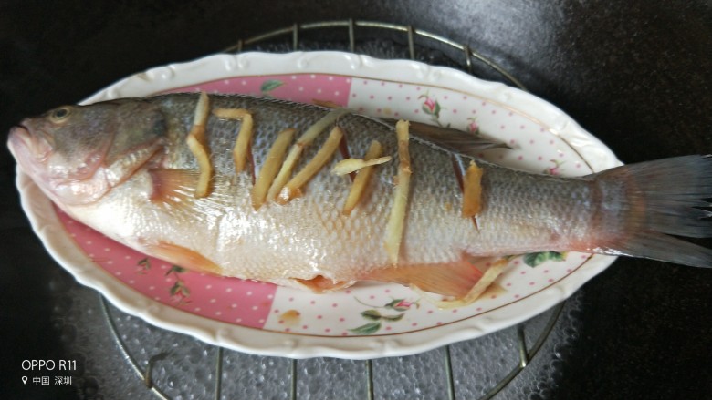 家常菜清蒸鲈鱼,开水上锅蒸，去掉葱段