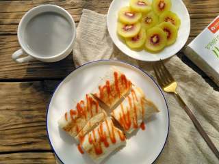 罗勒香肠吐司卷,
是不是很简单？这样也很方便小朋友食用，再配上水果，豆浆或牛奶，一顿丰盛又营养的早餐就好了。