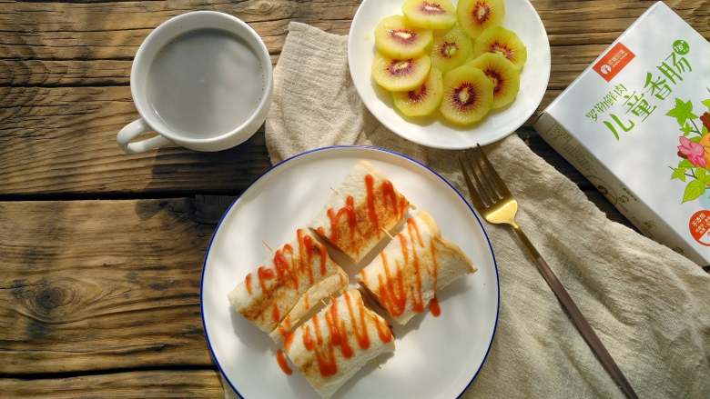 罗勒香肠吐司卷,
是不是很简单？这样也很方便小朋友食用，再配上水果，豆浆或牛奶，一顿丰盛又营养的早餐就好了。