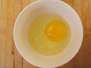 韭菜炒鸡蛋,把鸡蛋打入碗中。