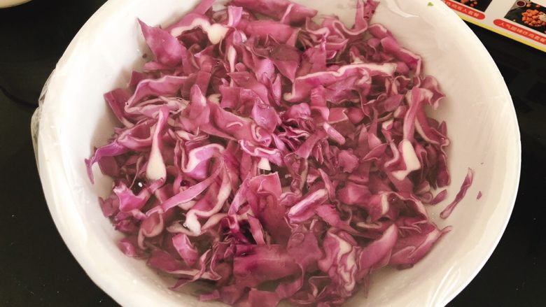 爆炒紫甘蓝, 用筷子搅拌均匀，包上保鲜膜，腌制1.5～2小时，使紫甘蓝腌出水分。