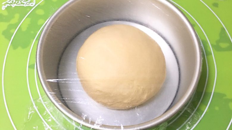 椰蓉叶子面包,整理滚圆后放入模具，盖上保鲜膜。