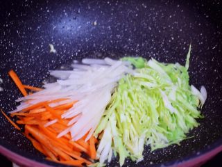炒河粉,原锅倒入适量的食用油烧热，再放入胡萝卜、白萝卜、包菜翻炒至变软
