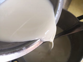 牛奶椰丝小方,再把搅拌均匀的玉米淀粉混合物倒入煮沸的牛奶混合液中，并且不断搅拌，