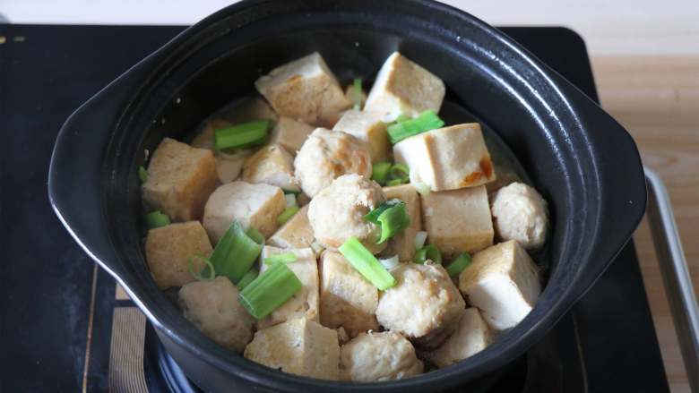 肉丸豆腐砂锅煲,继续炖煮一分钟后关火，加入适量盐调味，撒入蒜叶即可；