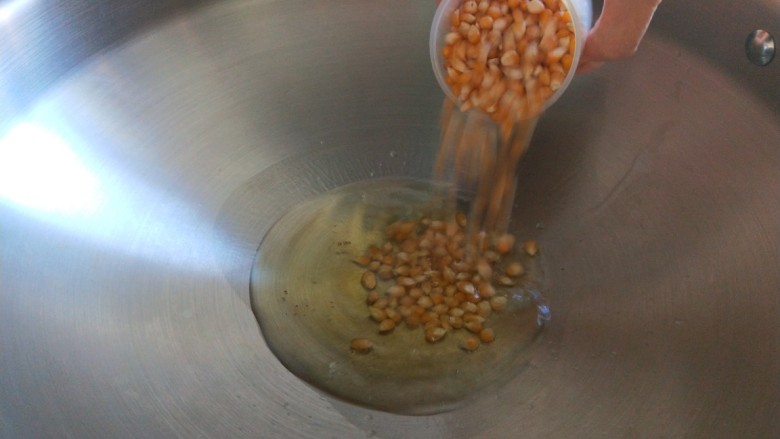 新文美食  自制爆米花,倒入玉米粒。