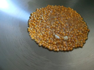 新文美食  自制爆米花,等看到有一两个玉米花开马上盖上锅盖。