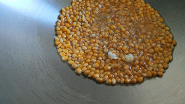 新文美食  自制爆米花,等看到有一两个玉米花开马上盖上锅盖。