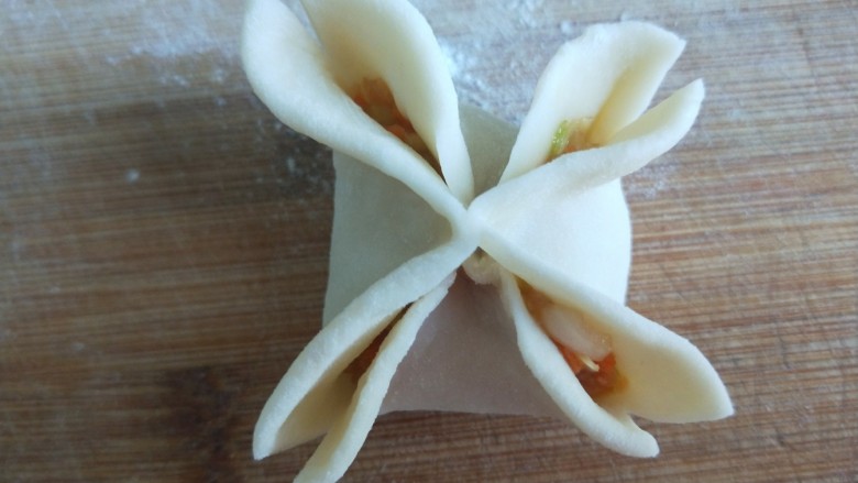 新文美食  莲花蒸饺,在用剪刀把四角剪开，两个角在捏紧。