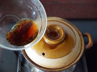 鳝鱼煲仔饭,盖上锅盖后在锅的边缘淋入调制好的香油、美极鲜味汁和开水酱汁