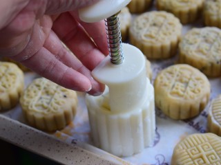 广式花生月饼,把包好的月饼表面抹一层薄薄的淀粉，用月饼模具压出花形