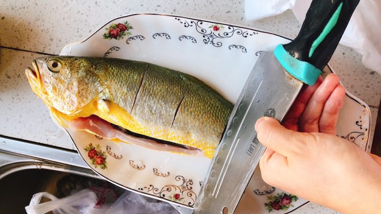 酸甜味清蒸黄瓜鱼,装盘里，用刀在鱼身上切3个口子，另一面也一样切。（不切段，目的是使鱼入锅是受热均匀，且更加入味）