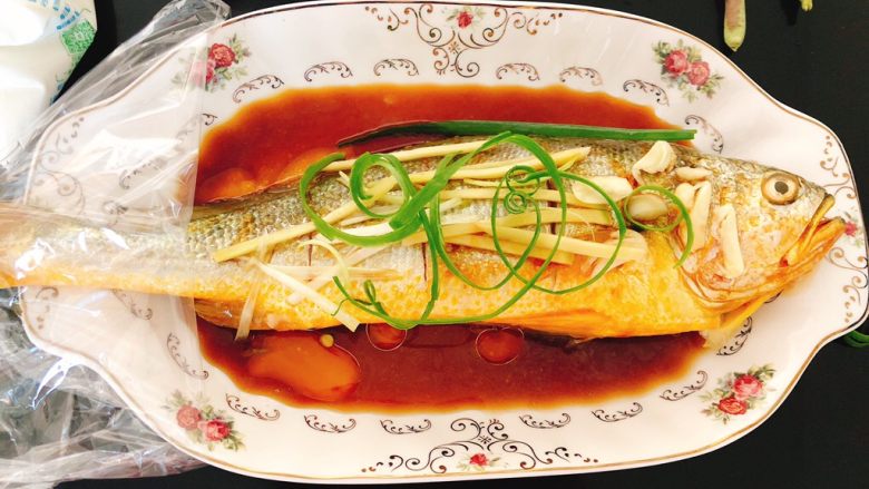 酸甜味清蒸黄瓜鱼,将葱叶撕开放到鱼身上。